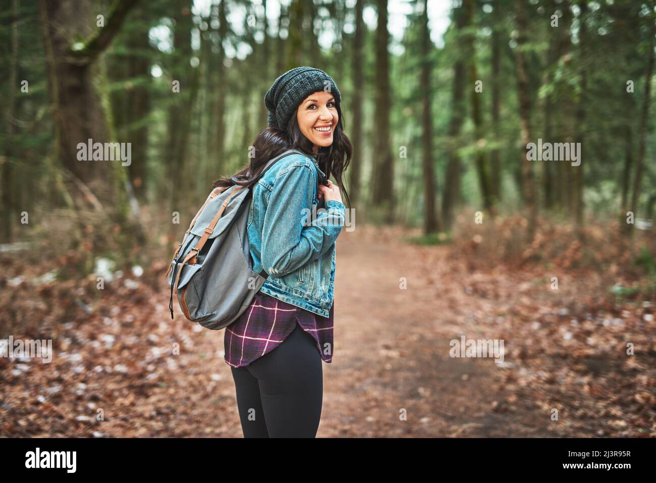 Auf ihrer Reise durch den Wald geht sie. Ausgeschnittene Aufnahme einer jungen Frau im Wald. Stockfoto