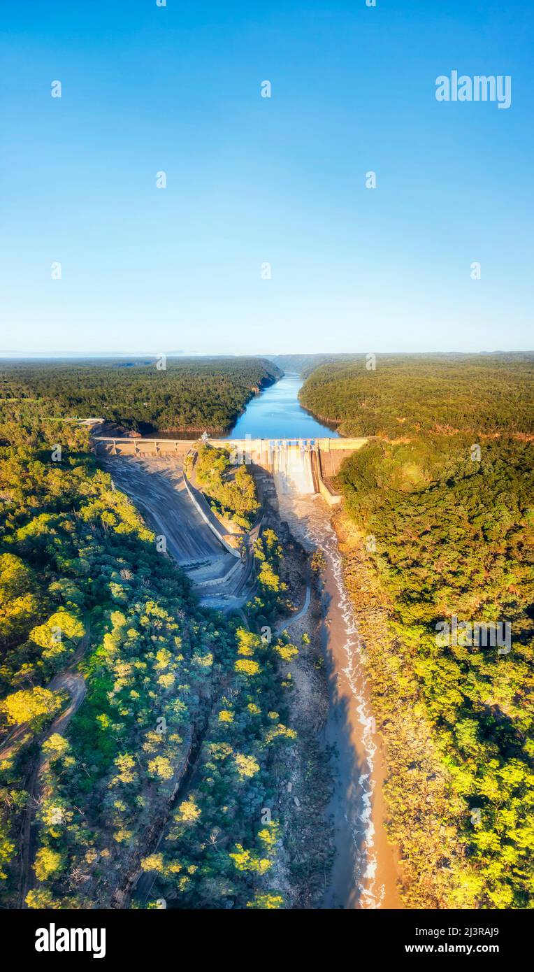 Langes vertikales Luftpanorama des Flusses Warragamba, eingeschlossen von einem Staudamm, der in der Hochwassersaison überläuft. Stockfoto