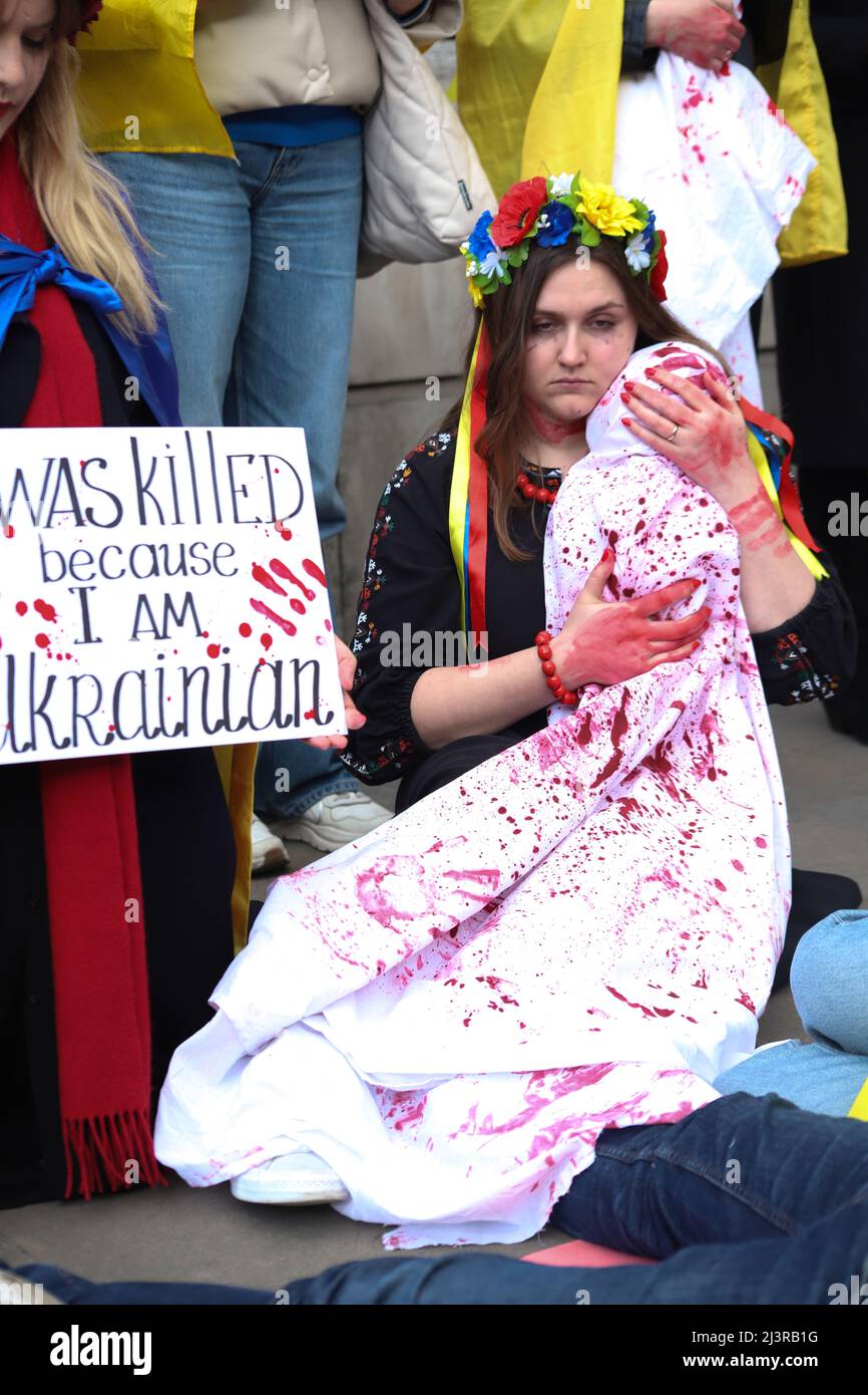 London, England, Großbritannien 9. April 2022 Stand mit Protest und Eintreten der Ukraine in der Downing Street. Die Demonstranten trugen traditionelle Kostüme und Plakate mit Aussagen über die Verbrechen russischer Soldaten und lagen mit gefesselten und angeketteten Händen. Stockfoto