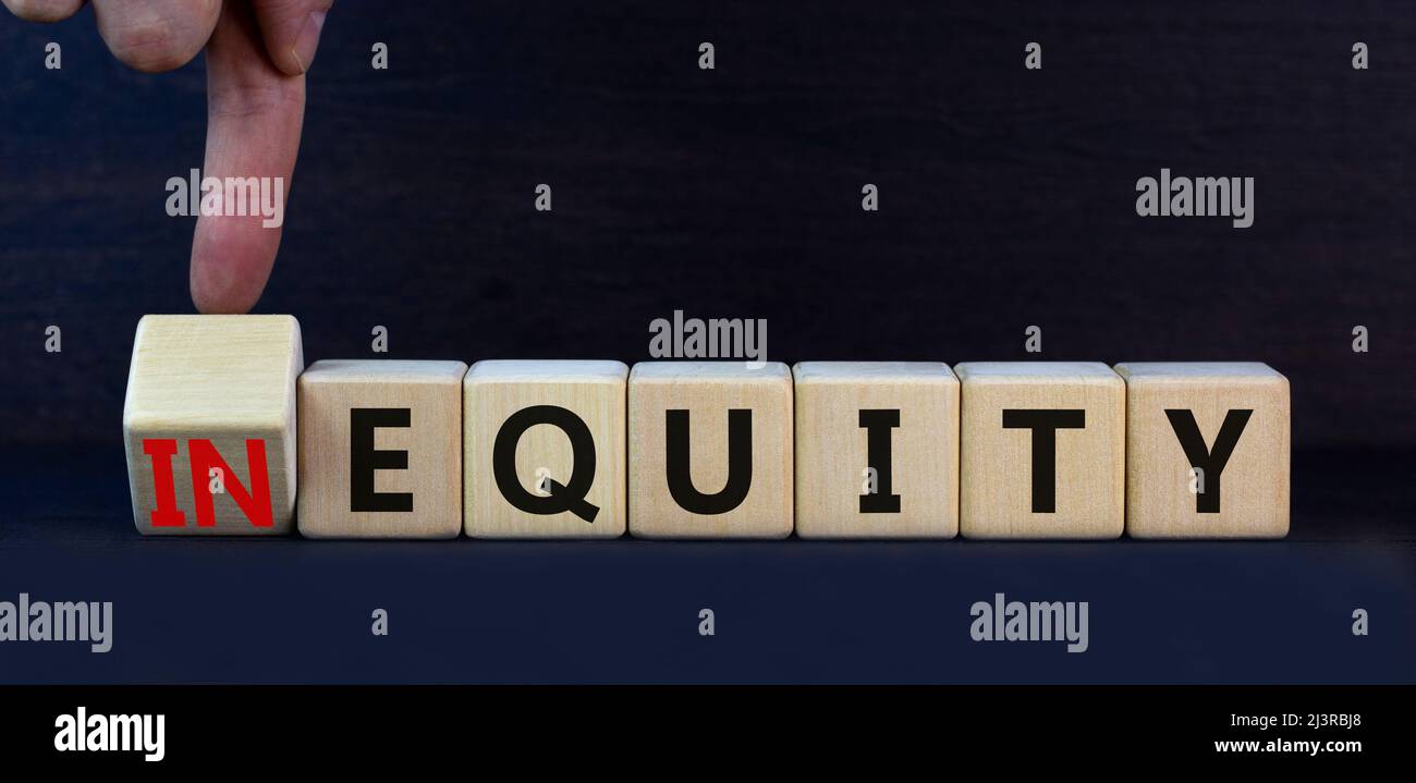 Symbol für Ungleichheit oder Eigenkapital. Drehten Holzwürfel und änderten das Konzeptwort InEquity in Equity. Schöne graue Tabelle grauen Hintergrund. Business und ine Stockfoto