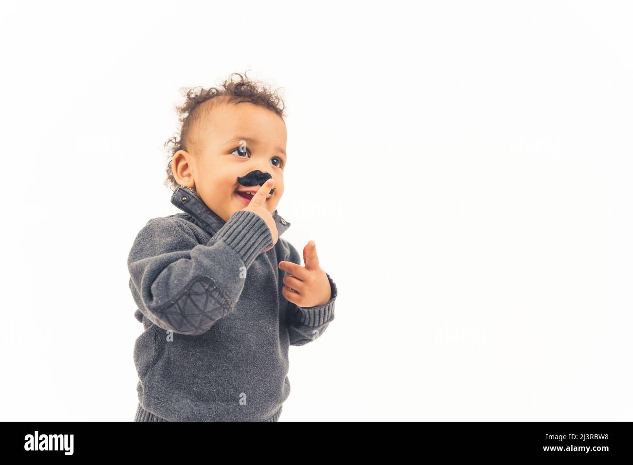 Lustige glücklich Hipster biracial Kind berühren seine gefälschte schwarzen Schnurrbart Requisiten auf weißem Hintergrund. Hochwertige Fotos Stockfoto