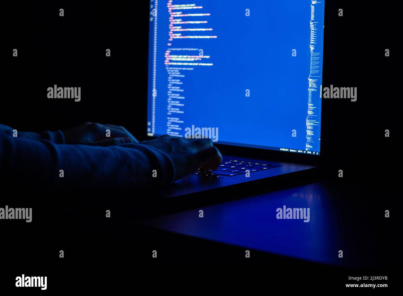Der Entwickler arbeitet nachts und macht Webprogrammierung mit javascript. Nahaufnahme von Hand und Computer Stockfoto