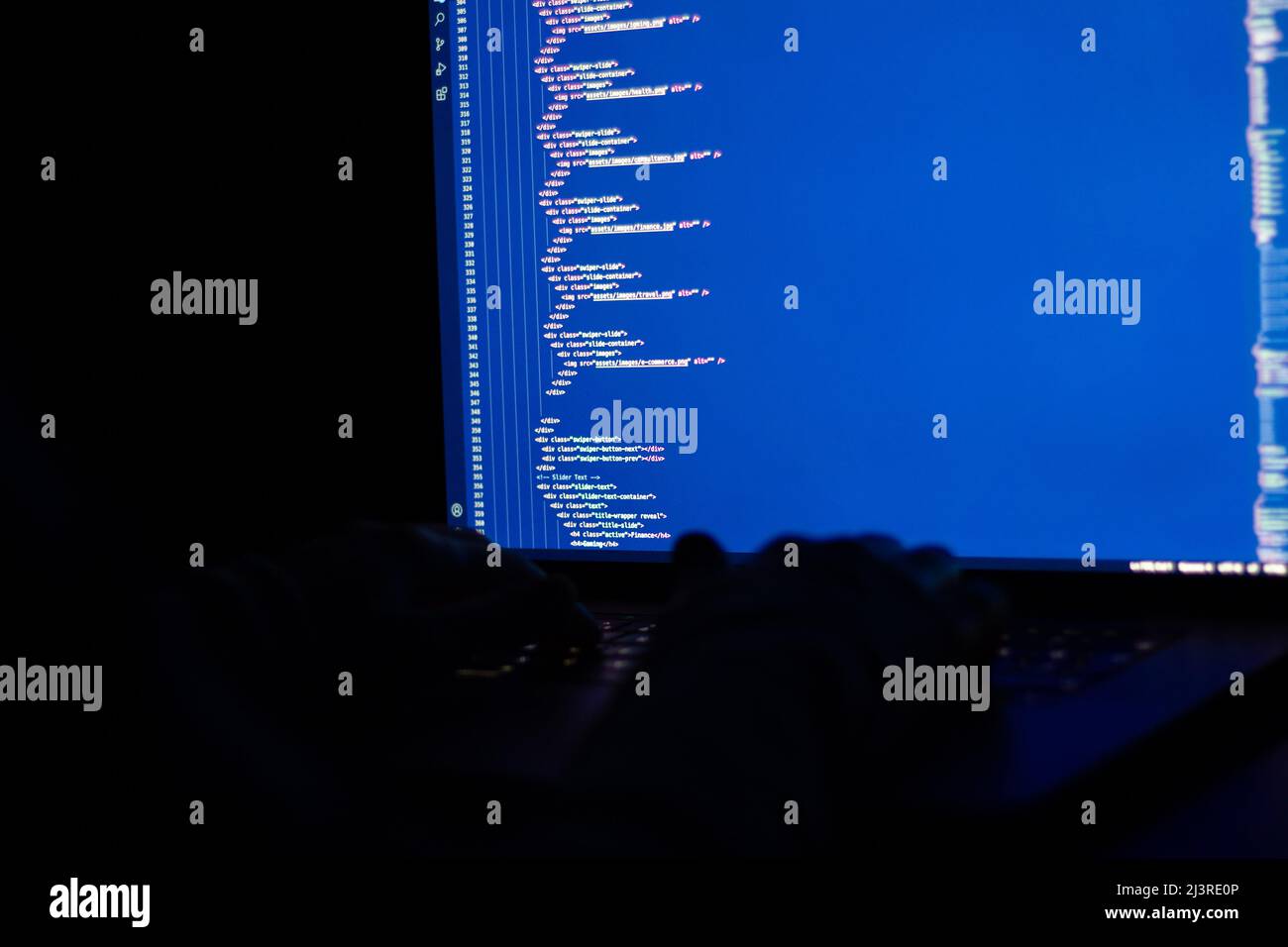 Der Entwickler arbeitet nachts und macht Webprogrammierung mit javascript. Nahaufnahme von Hand und Computer Stockfoto