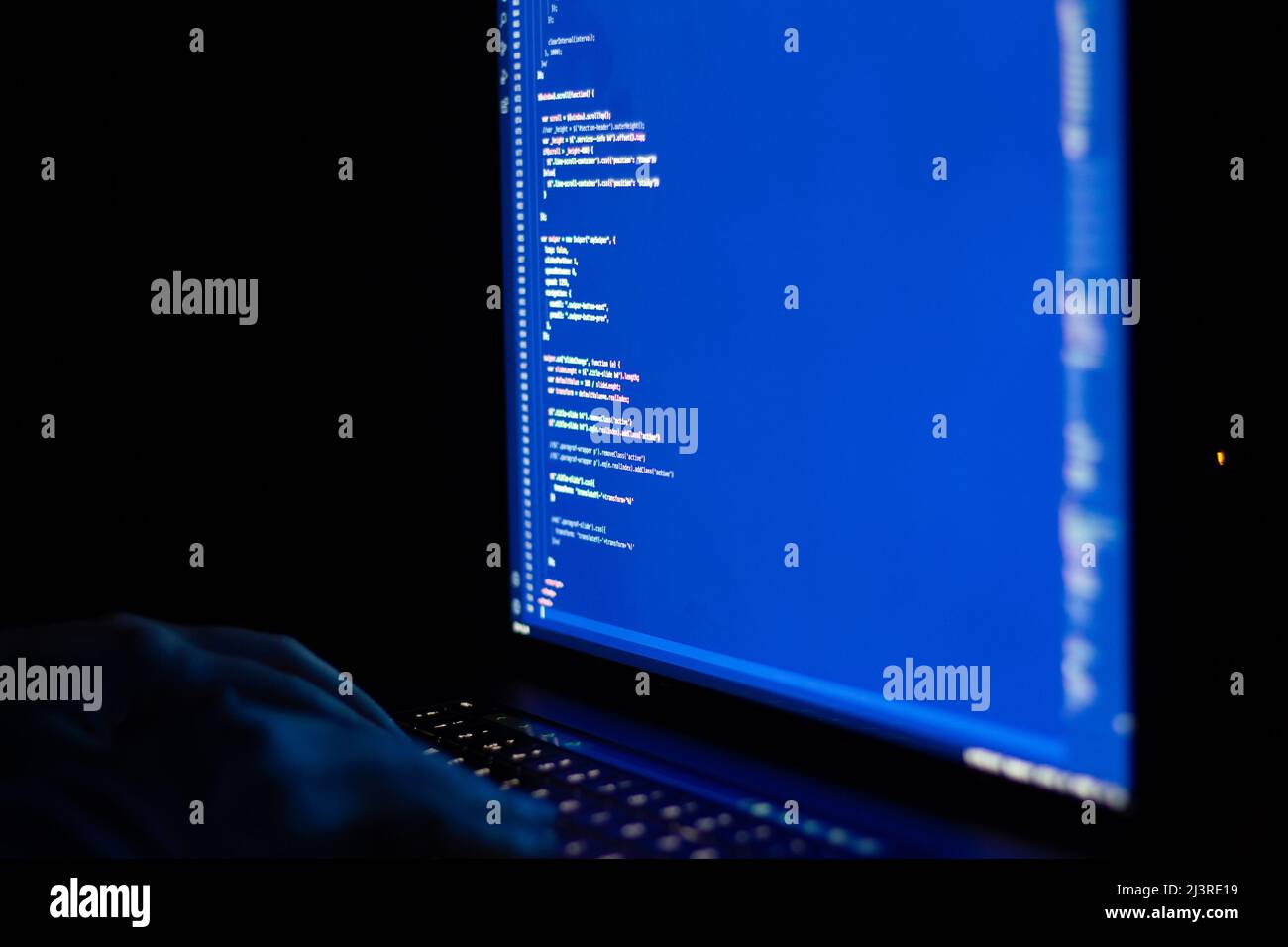 Freiberuflicher Webentwickler, der nachts arbeitet und das Web mit javascript programmiert wie ein Hacker. Nahaufnahme von Hand und Computer Stockfoto