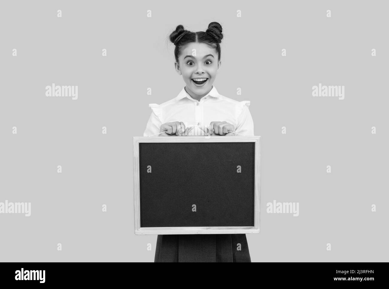 Stauntes Kind in Schuluniform mit Tafel auf blauem Hintergrund, Kopierraum, Werbung Stockfoto