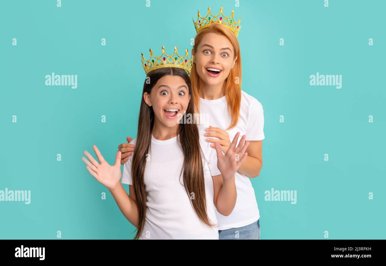 Überrascht Weitäugige egoistische Frau Mutter und Tochter Kind tragen Kronen blauen Hintergrund, Überraschung Stockfoto