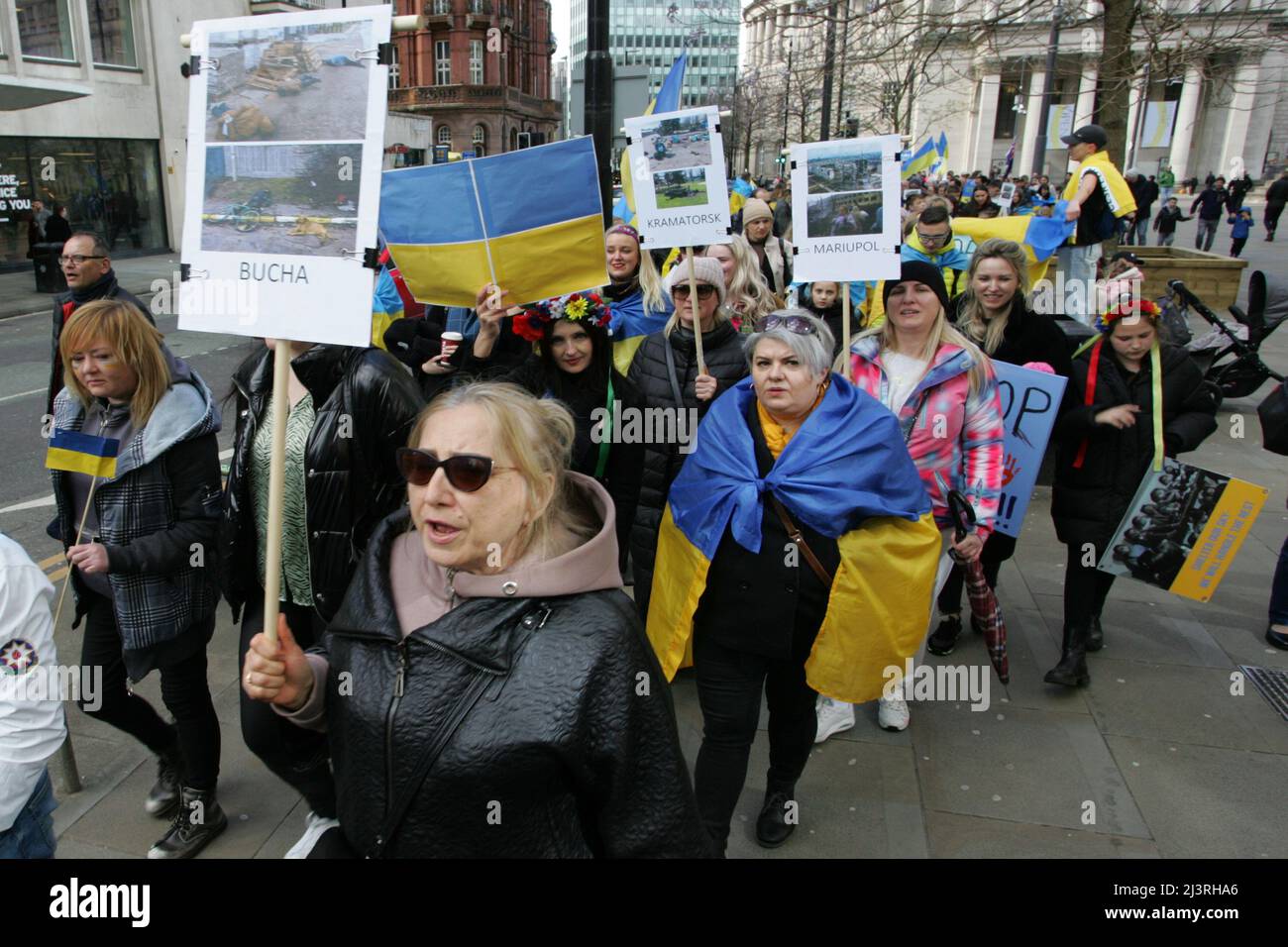 Ukrainische Protesterinnen in Manchester halten Plakate mit Fotoerinnerungen an die Gräueltaten der russischen Armee, die seit der Invasion in Städten in der ganzen Ukraine begangen wurden rund 200 Mitglieder der ukrainischen Gemeinde in Manchester sowie Ukrainer des Kulturzentrums „Dnipro“ marschierten durch das Stadtzentrum. Sie forderten ein Ende der Feindseligkeiten, der Invasion und des Mordes an Zivilisten, die gegen sie verübt wurden, seit Russland im Februar dieses Jahres ohne Provokation in die Ukraine einmarschierte. Viele ukrainische Kinder waren anwesend, als sie plakate hielten, auf denen die von durchgeführten Gräueltaten hervorgehoben wurden Stockfoto