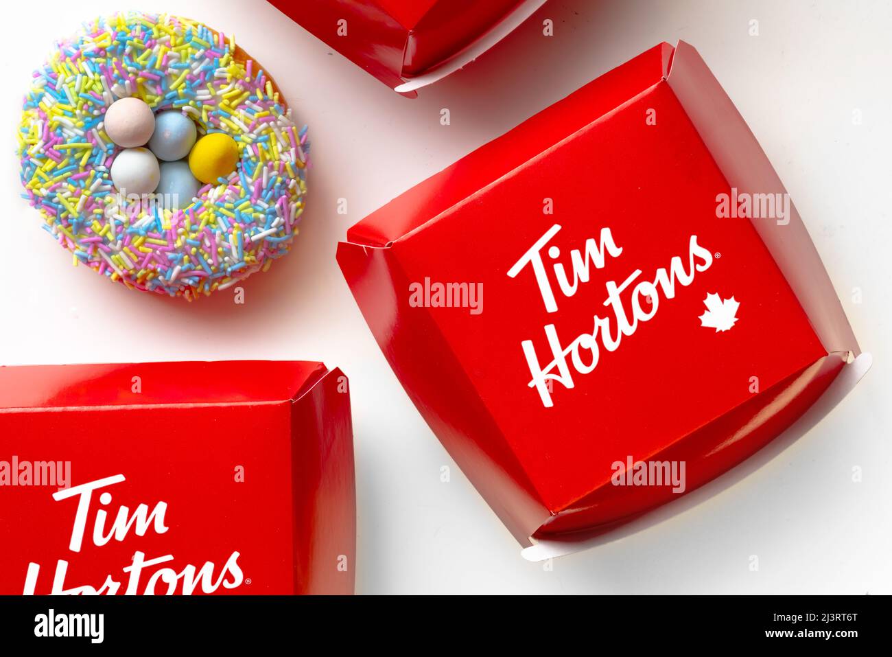 Calgary, Alberta, Kanada. 9. April 2022. Ein Tim Hortons Easter Donut mit Food Sandwiches Containern auf weißem Hintergrund Stockfoto