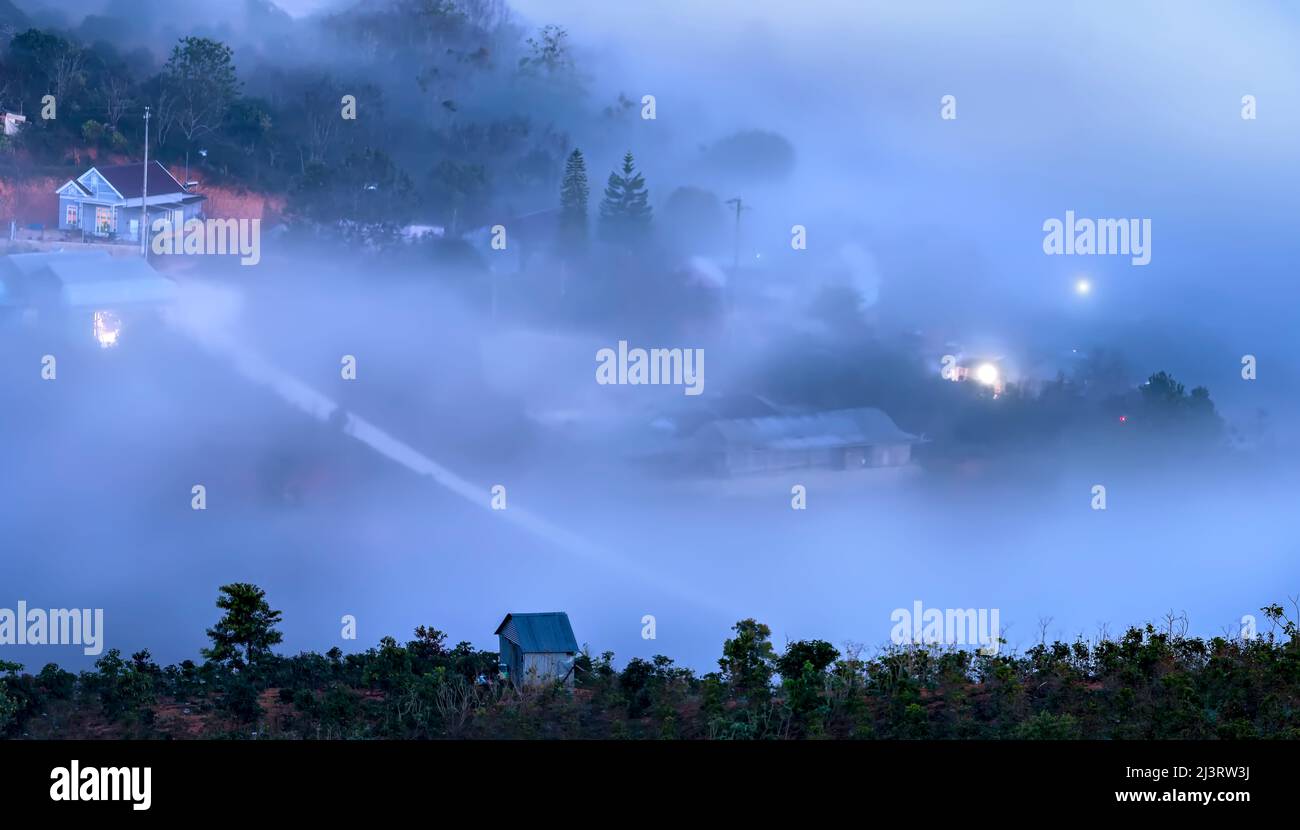 Nachtszene am Hang eine kleine Stadt im Nebel, umgeben von bunten Häusern und Lichtern, macht die Nacht im Hochland von Da Lat, Vietnam, so schön Stockfoto