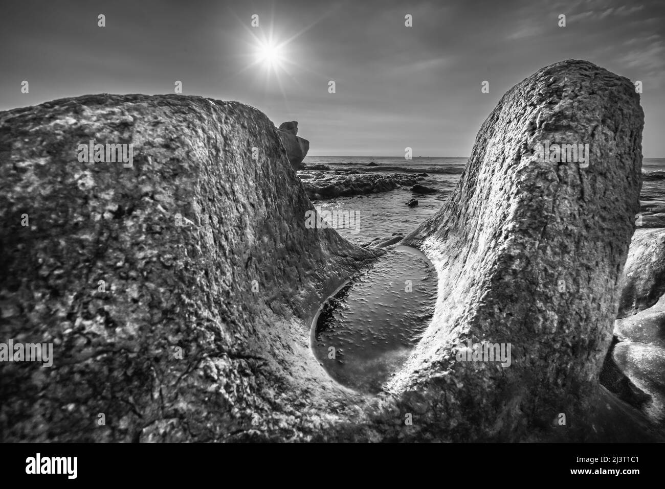 Felsiger Strand und grünes Moos am Sonnenaufgangshimmel an einem wunderschönen Strand in Zentralvietnam Stockfoto