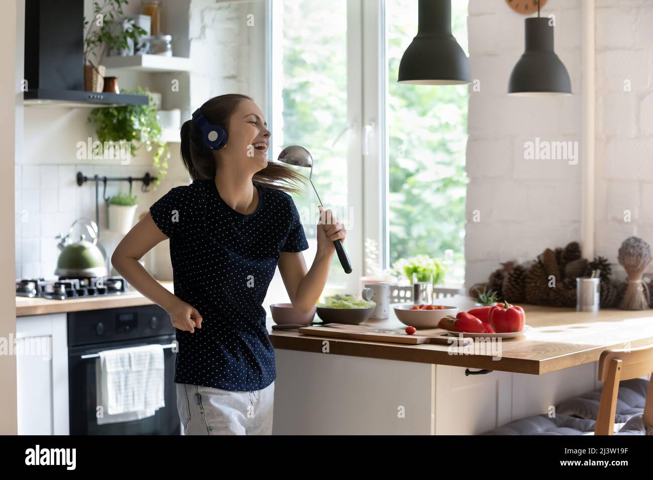 Frau hält Kelle, singen, genießen Sie hochwertigen Sound über Kopfhörer Stockfoto