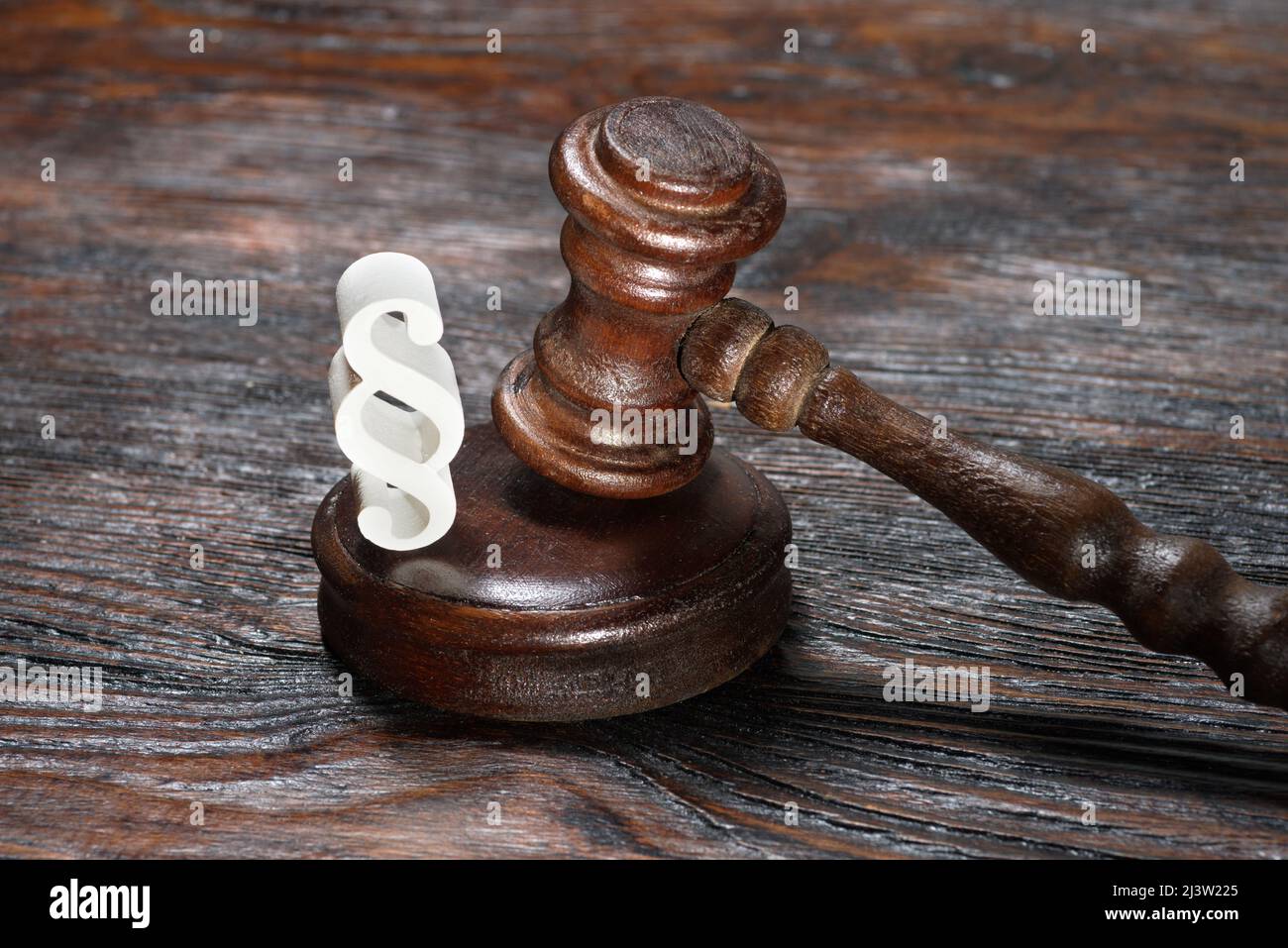 Hölzerne Richter gavel und Symbol für Recht und Gerechtigkeit auf dem Tisch in einem Gerichtssaal oder Strafverfolgungsbehörde auf dunklem Hintergrund Stockfoto