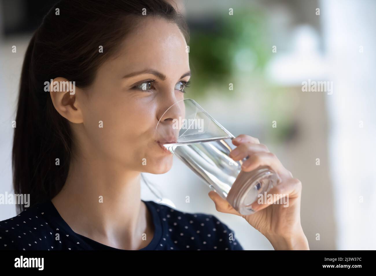 Nahaufnahme Attraktive 20s Frau hält Glas trinken natürliches Wasser Stockfoto