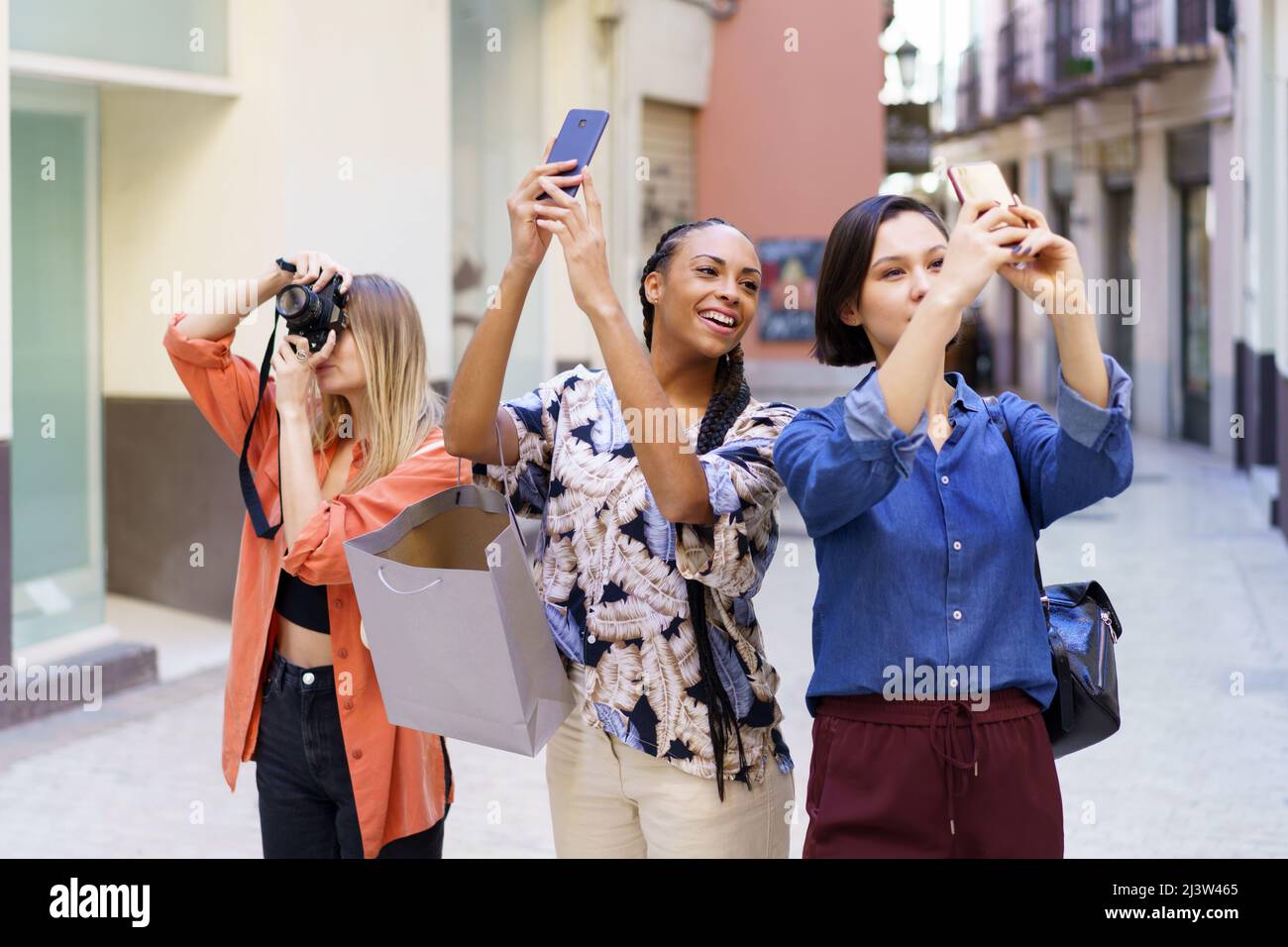 Inhalte multirassische Freunde, die Fotos von der Straße machen Stockfoto