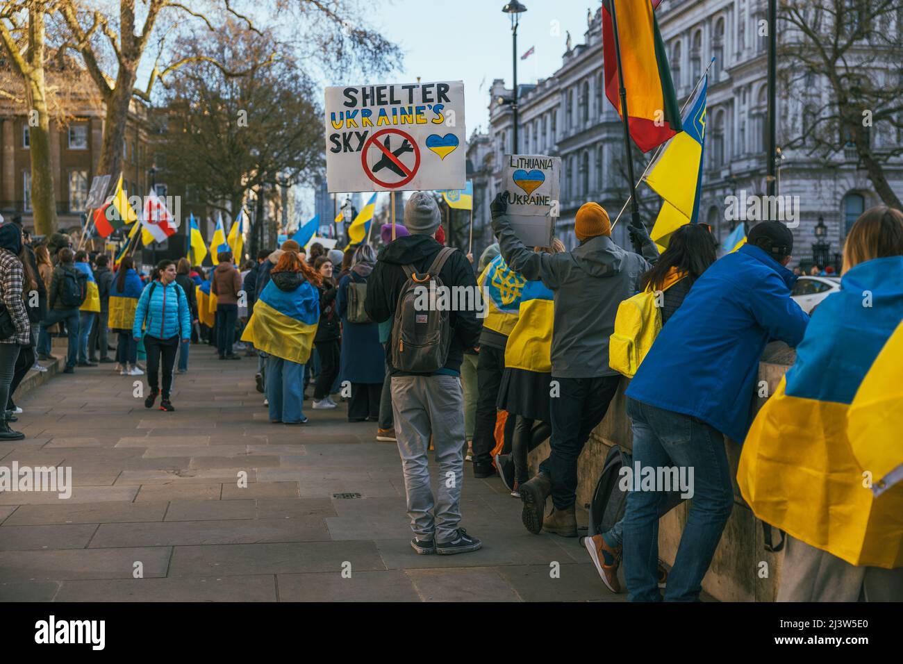 Demonstranten, die ukrainische Flaggen tragen, in Whitehall, London. Tausende von Menschen marschierten in Solidarität mit der Ukraine, während Russland seinen Angriff fortsetzt. Stockfoto