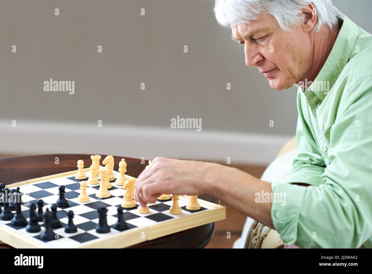 Schach stimuliert seinen Geist. Aufnahme eines älteren Mannes, der zu Hause eine Partie Schach spielt. Stockfoto