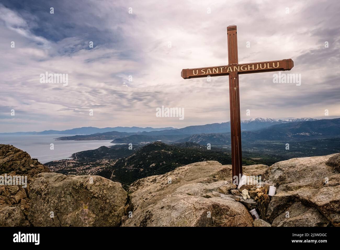 Überqueren Sie den Gipfel der Cima Sant'Anghjulu in der Nähe von Corbara in der Region Balagne von Korsika mit der Küste und schneebedeckten Bergen in der Ferne Stockfoto