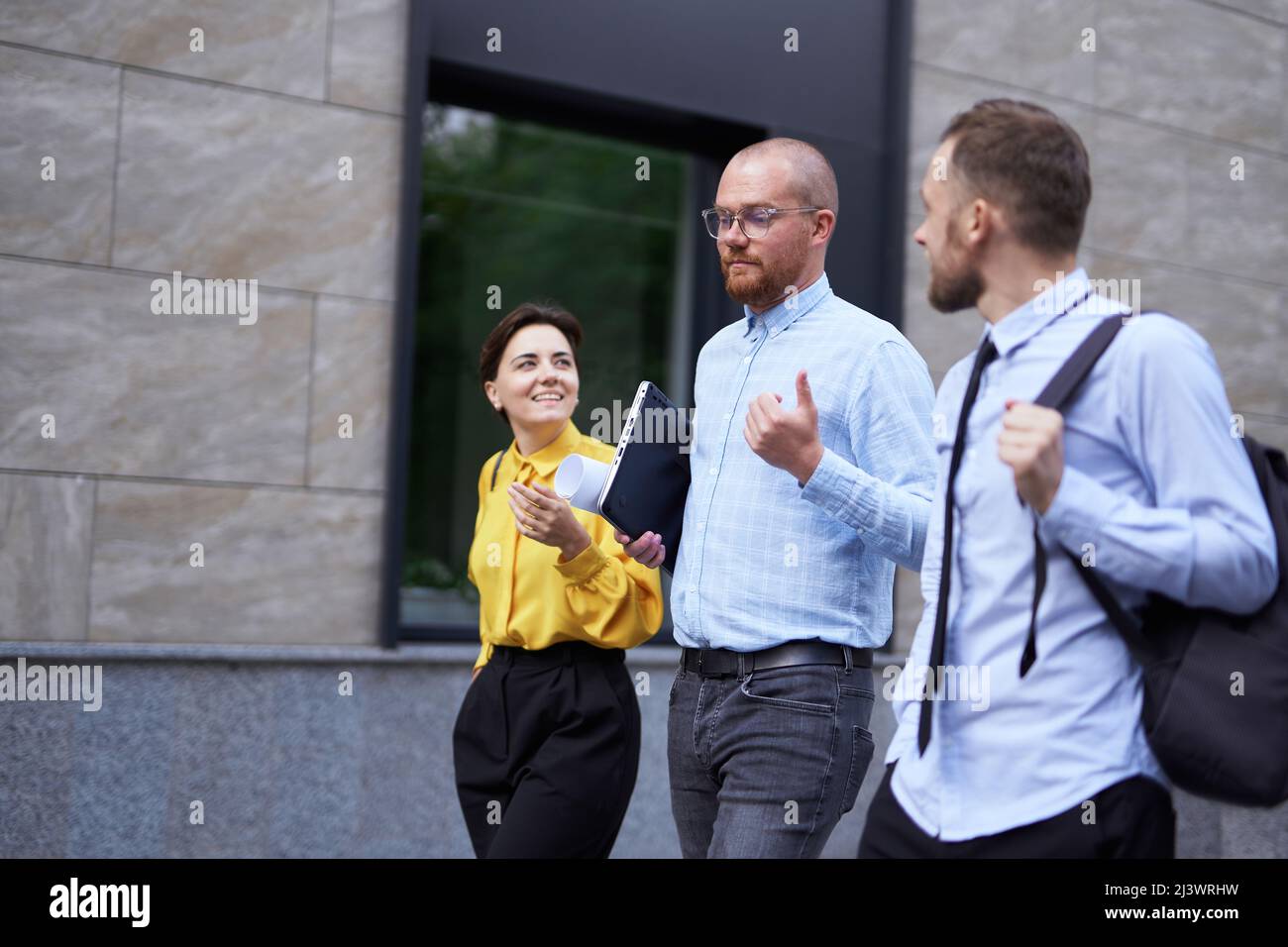 Geschäftsleute Brainstorming oder Diskussion Projekt im Freien zu Fuß. Drei Angestellte in formeller Kleidung, die in der Innenstadt in der Nähe des Büros auf der Straße entlang gehen, mit städtischem Hintergrund. Hochwertige Fotos Stockfoto