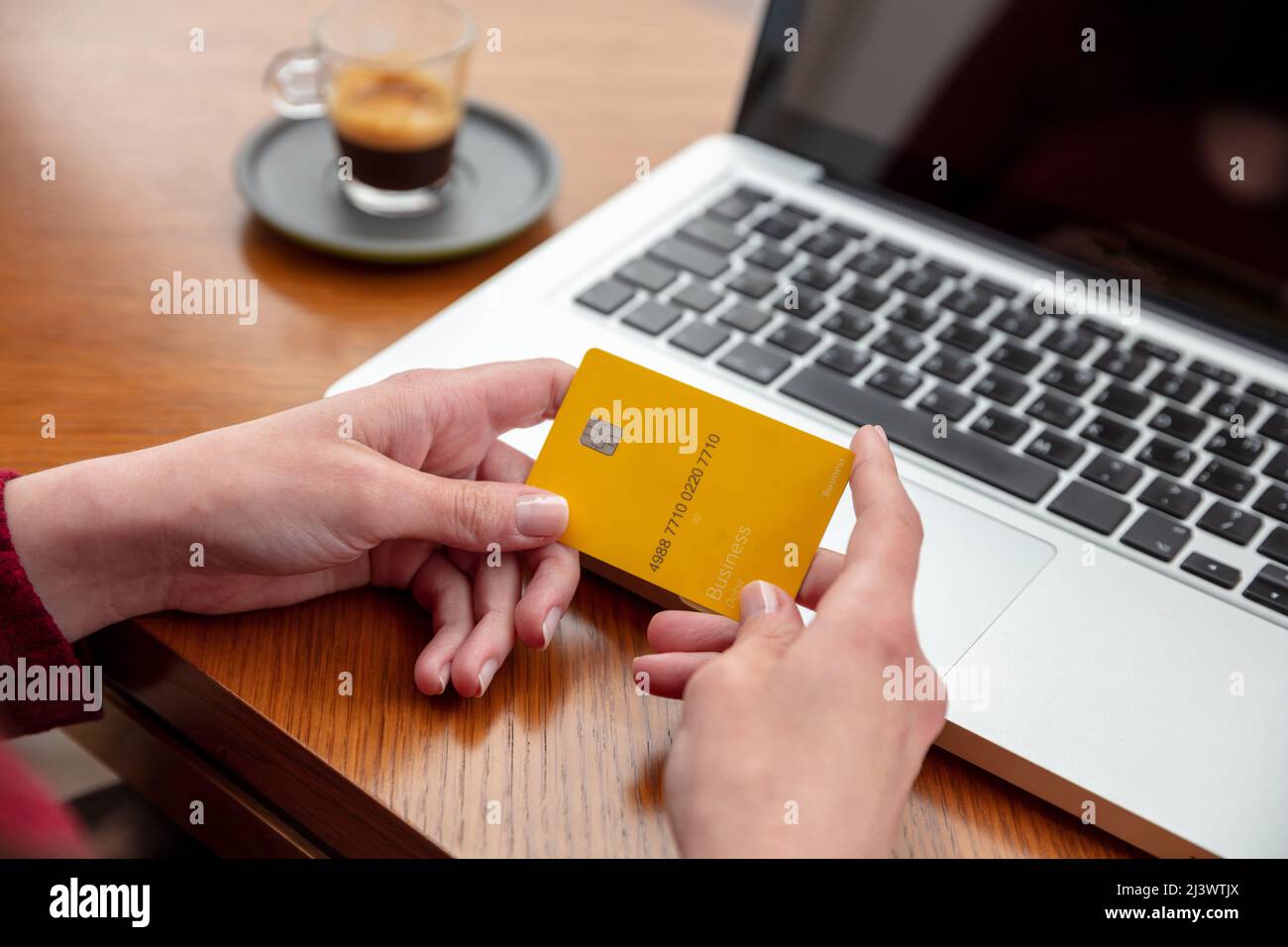 Bankkreditkarte, weibliche Hände halten leere gelbe Plastikkarte, Online-Zahlung und Einkaufen mit Computer-Laptop, Nahaufnahme Stockfoto