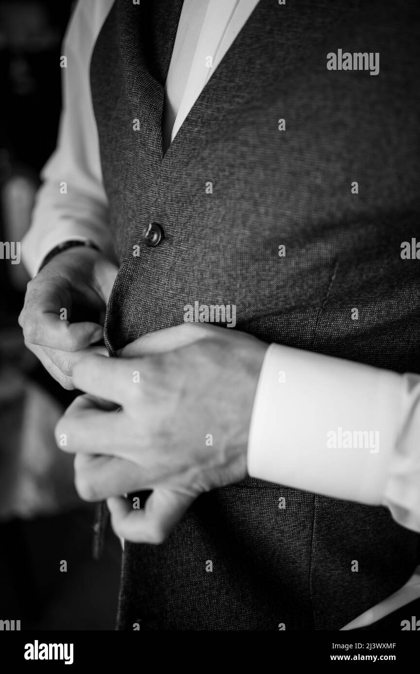 Der Mann schnallte einen Knopf an seiner Jacke Stockfoto