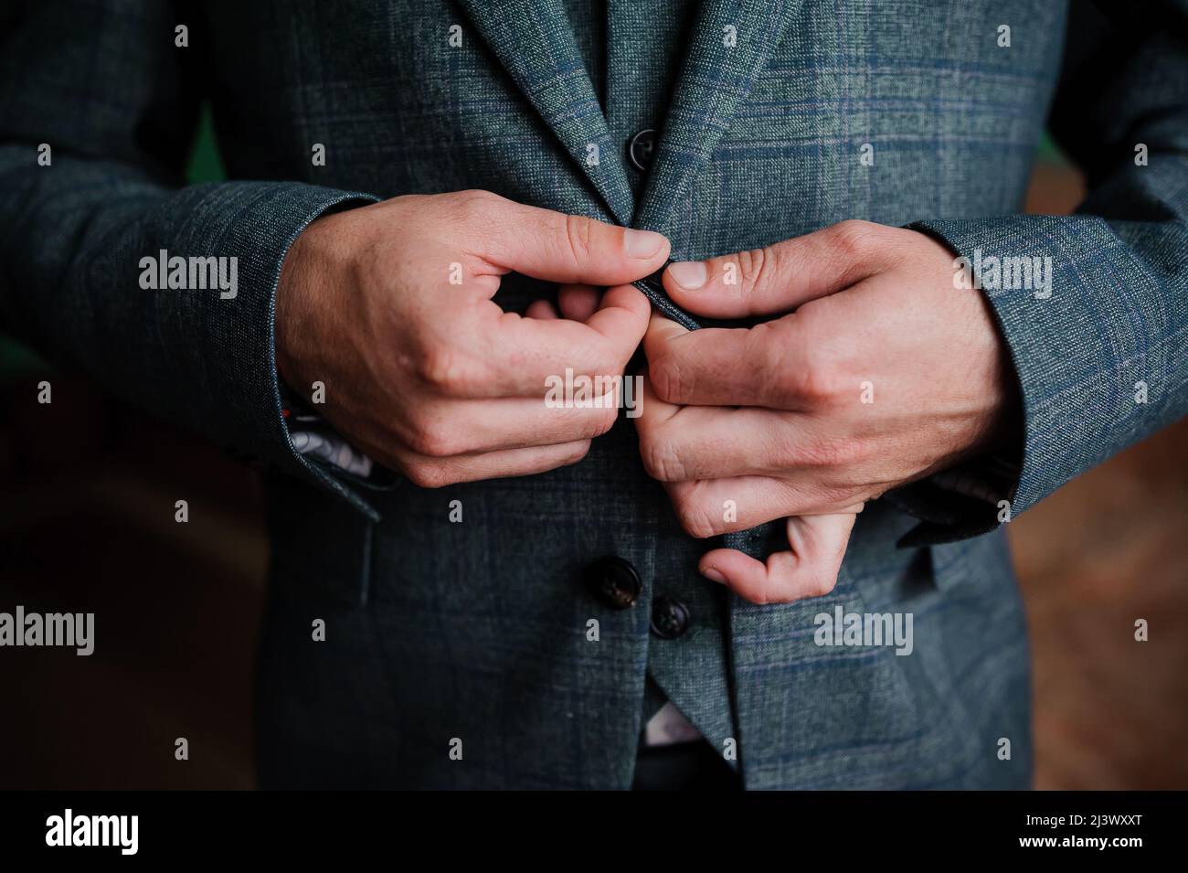 Der Mann schnallte einen Knopf an seiner Jacke Stockfoto