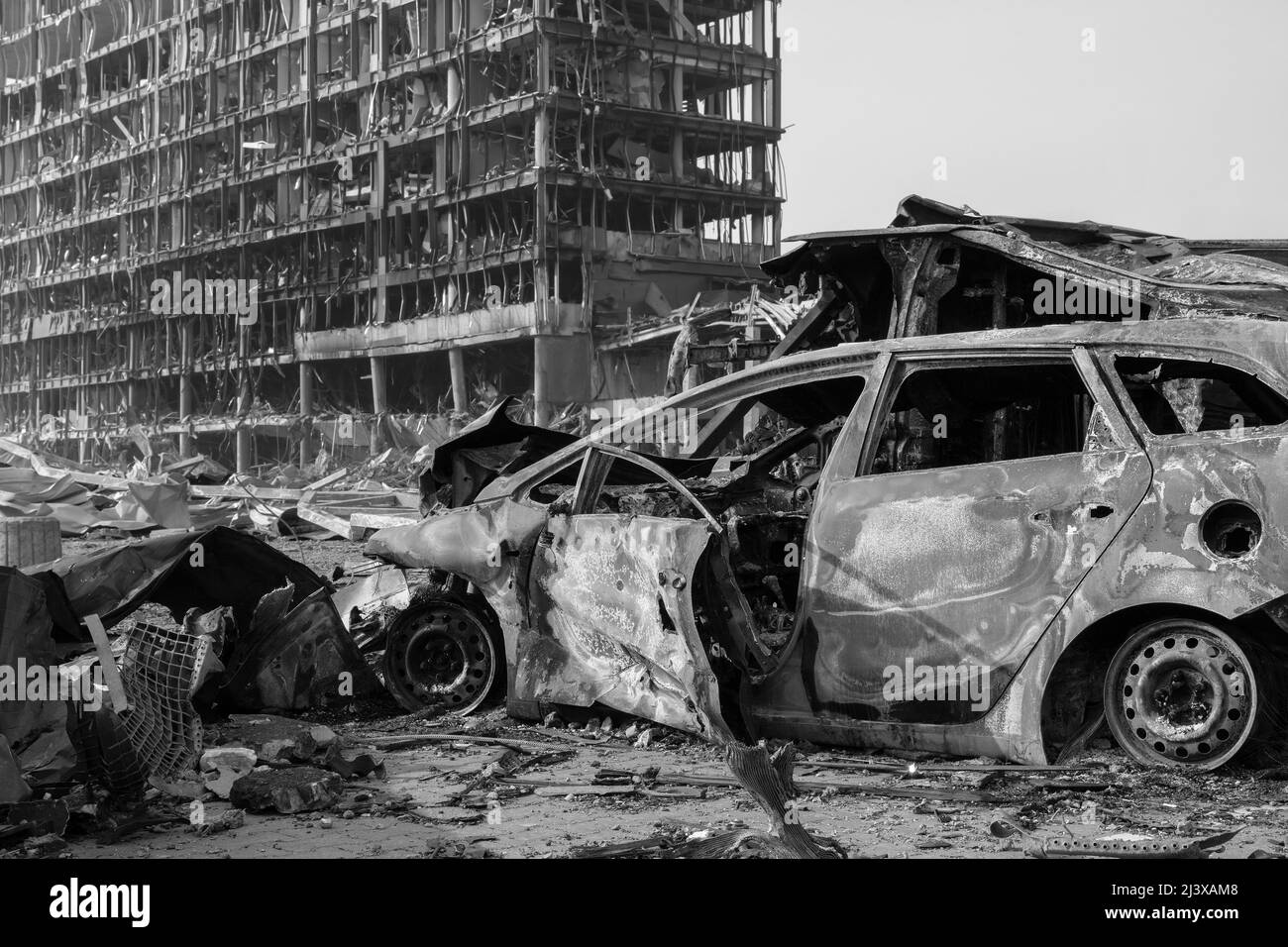 Nach der Shell von Zivilisten bombardiert Stadt Schaden Auto. 2022 Russische Invasion der Ukraine Krieg zerrissene Stadt zerstört Auto brennen aus. Bombe Angriff Russland Krieg Stockfoto