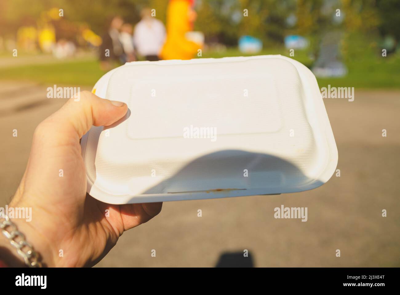 Die Hand des Mannes hält eine Schaumstoffkiste mit Nahrung. Stockfoto