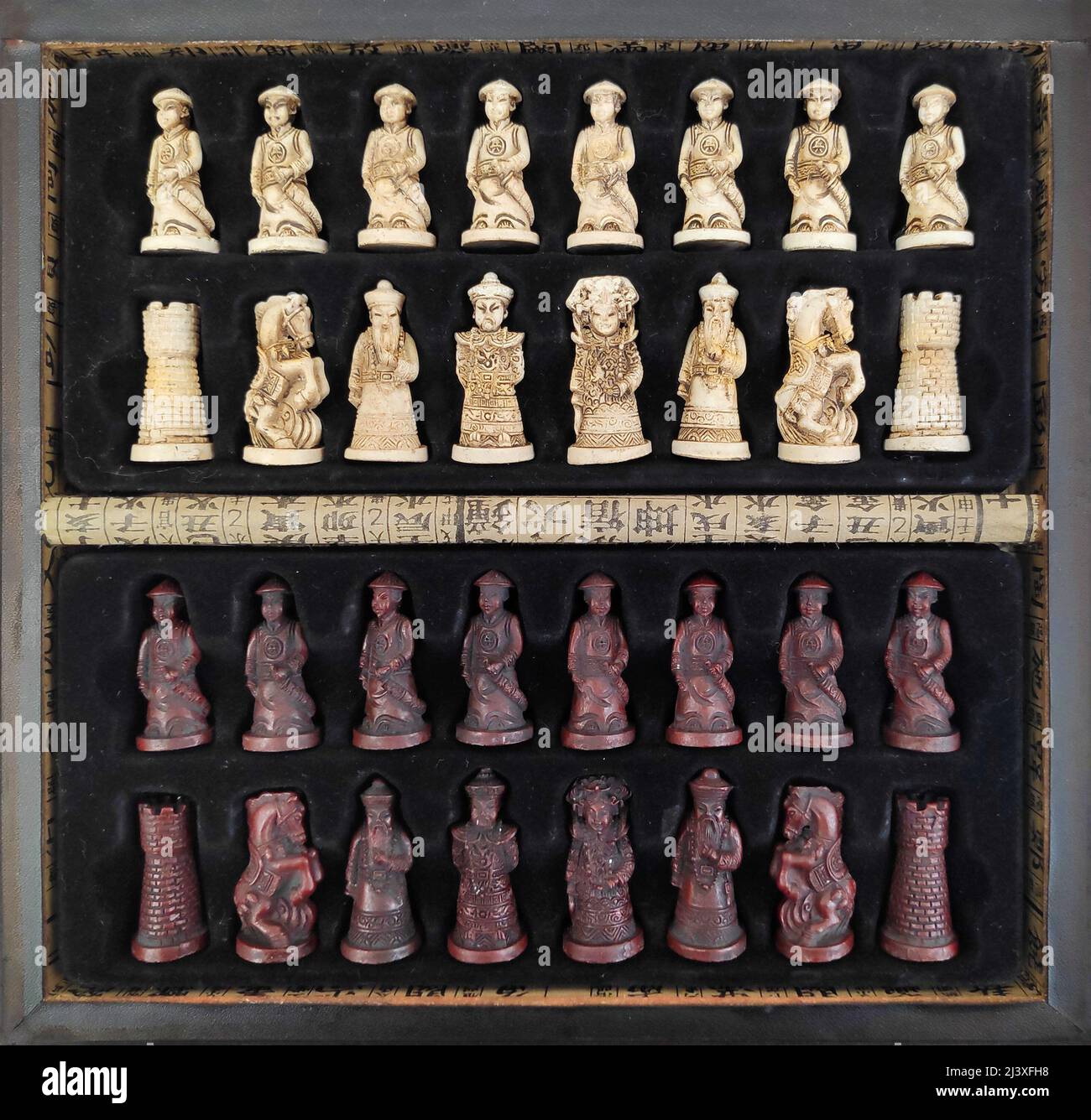 Eine lederbezogene Holzkiste, gefüllt mit Schachfiguren im chinesischen Stil. Stockfoto