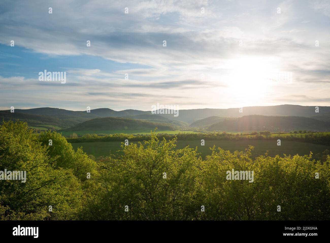 Schöne grüne Berglandschaft mit Sonne und Sonnenstrahlen über den Hügeln. Stockfoto