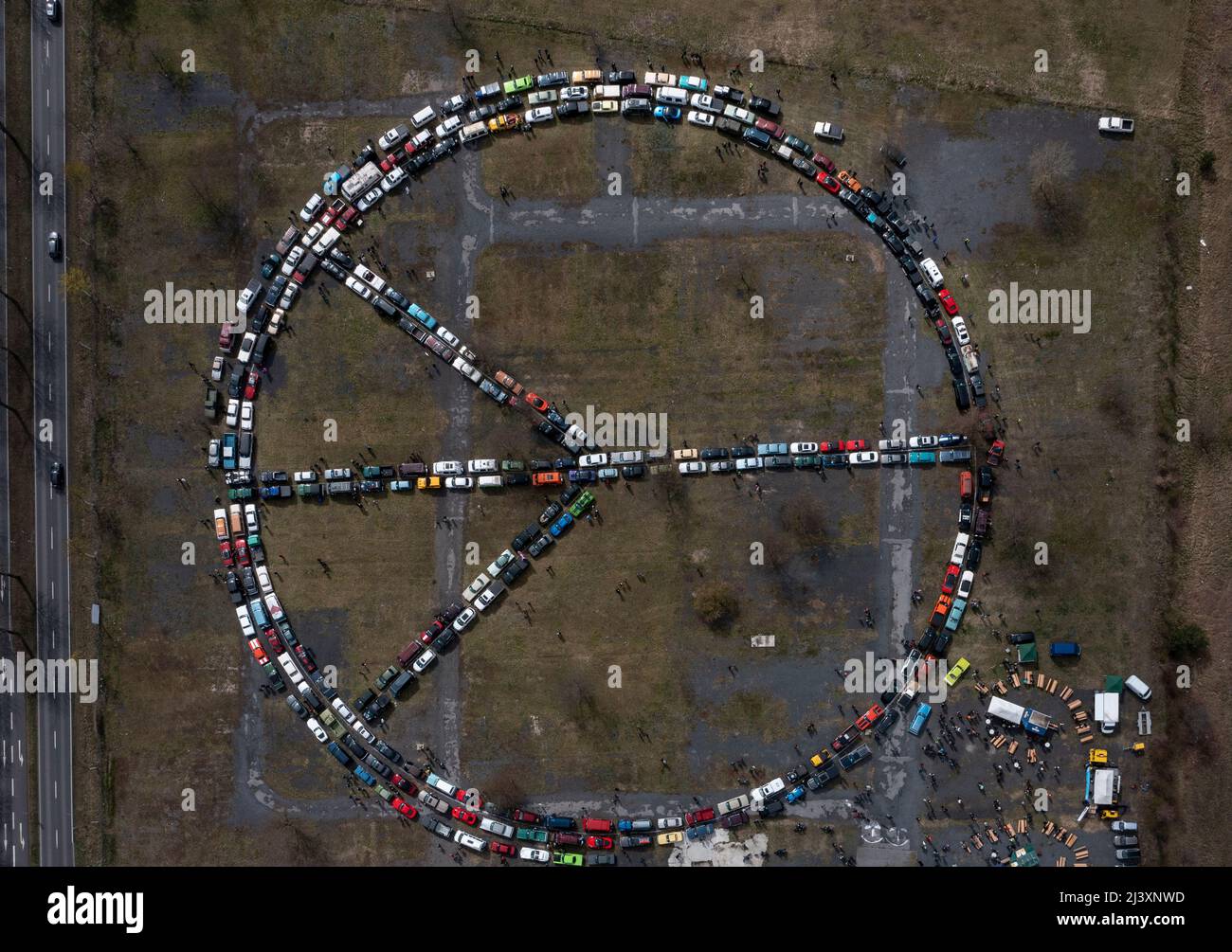 10. April 2022, Brandenburg, Königs Wusterhausen: Die Mitglieder und Freunde des Vereins 'Rummblubbern und Rummtuckern Königs Wusterhausen' haben einen neuen Weltrekord aufgestellt. Auf einer Wiese stellten sie mit Fahrzeugen das größte Friedensschild von Oldtimern und US-Autos zusammen. (Drohnenaufnahme) Foto: Paul Zinken/dpa Stockfoto
