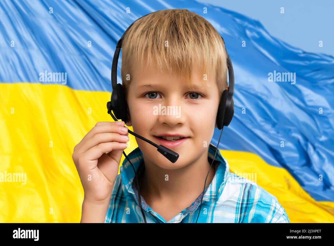 Kind auf dem Hintergrund der Flagge der Ukraine Stockfoto