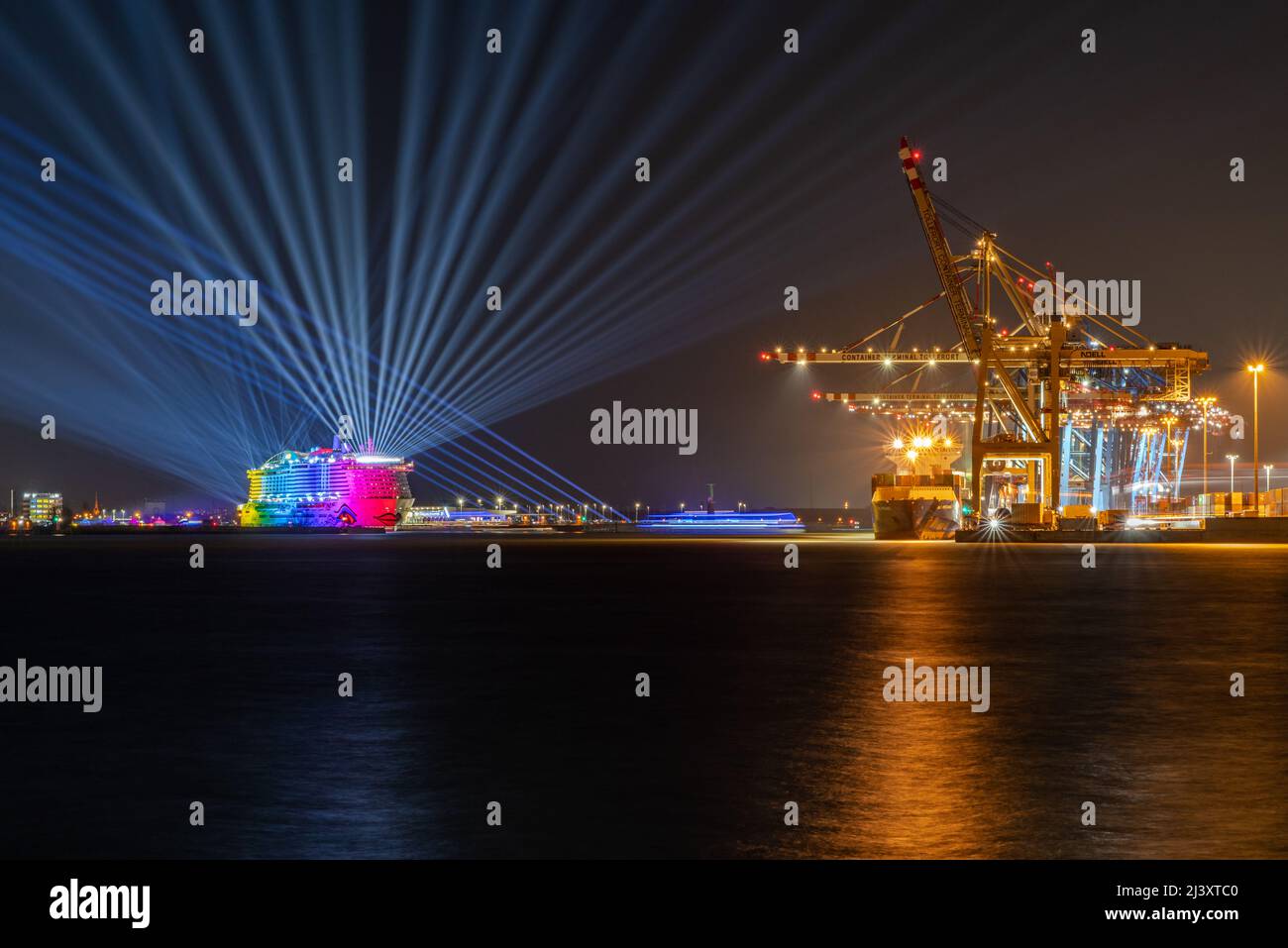 Hamburg, Deutschland- 04092022: Nachtaufnahme des Hamburger Hafens mit dem Containerterminal Tollerort und dem Kreuzfahrtschiff AIDAcosda. Stockfoto