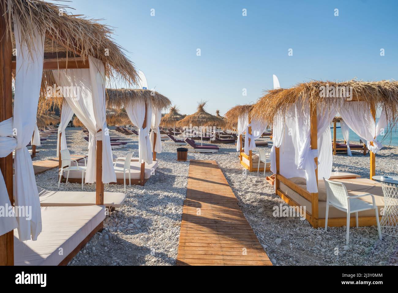 Baldachin Strandbett mit weißen Vorhängen an einem leeren Strand im Sommer Stockfoto