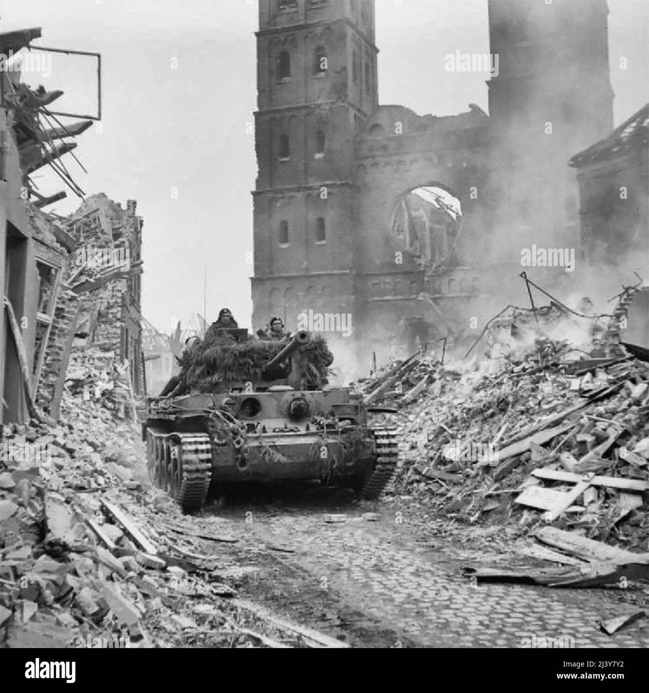 Die britische Armee in Nordwesteuropa 1944-45 Ein Cromwell-Panzer von 15./19. King’s Royal Hussars, 11. Armoured Division, mit Infanterie an Bord, dringt durch die Trümmer von Uedem, Deutschland, am 28. Februar 1945 vor. Stockfoto
