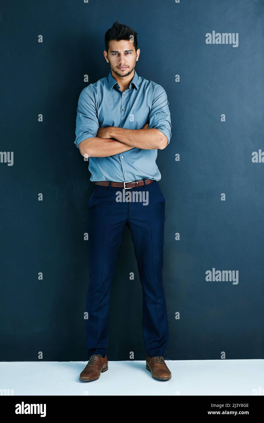 Ich stoppte nicht, bis ich die Erfolgsstraße erreiche. Studioporträt eines hübschen jungen Geschäftsmannes, der mit gekreuzten Armen vor grauem Hintergrund steht Stockfoto