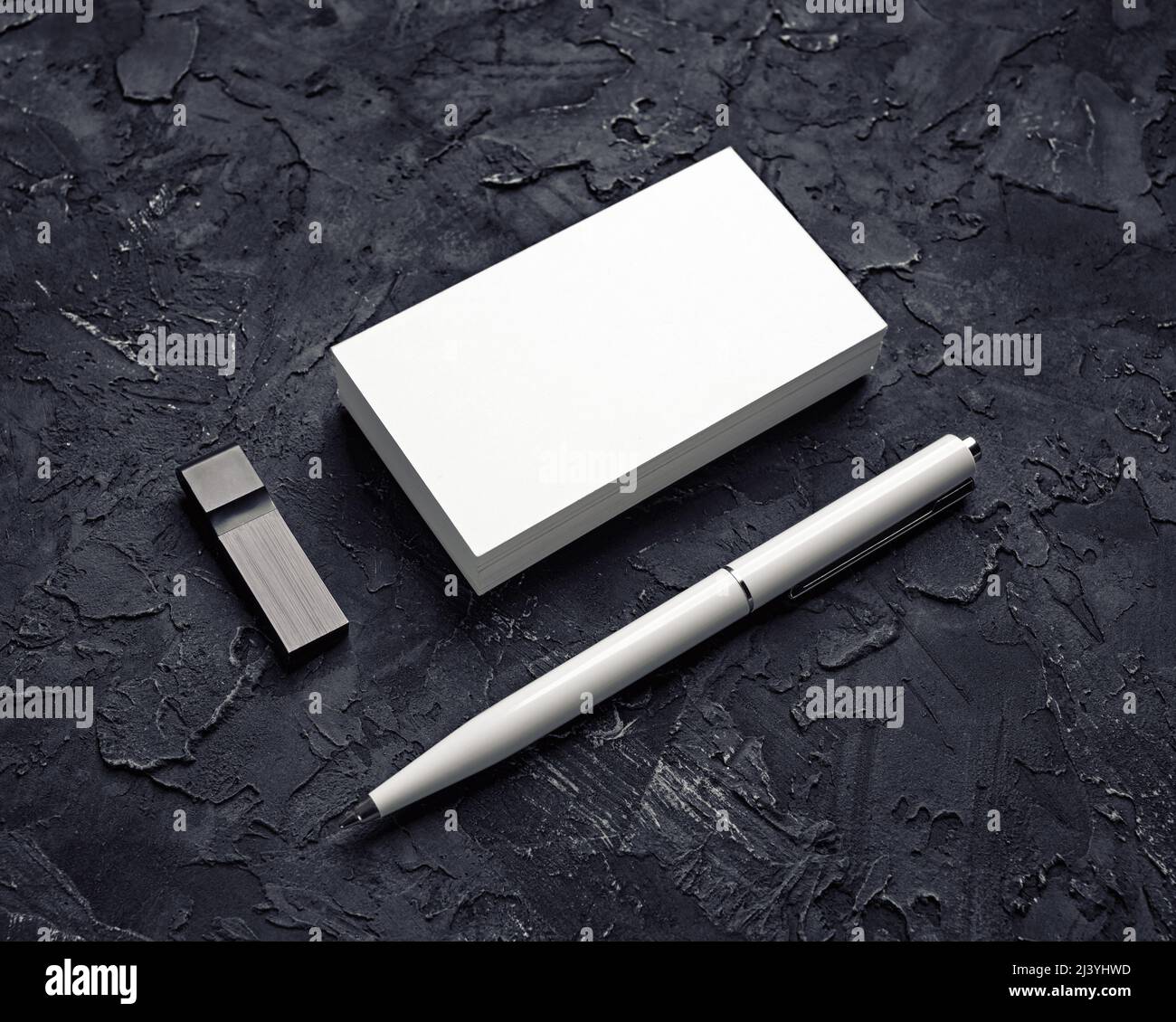 Leere Visitenkarte, usb-Stick und Stift auf schwarzem Gips-Hintergrund. Modell für Markenidentität. Vorlage für Portfolios von Grafikdesignern. Stockfoto