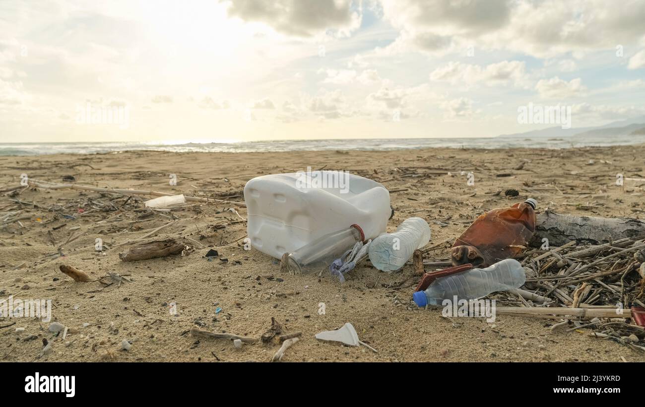 Weggeworfene Plastikverschmutzung auf kontaminiertes Ökosystem der Meeresküste, Umweltschäden durch Abfälle Stockfoto