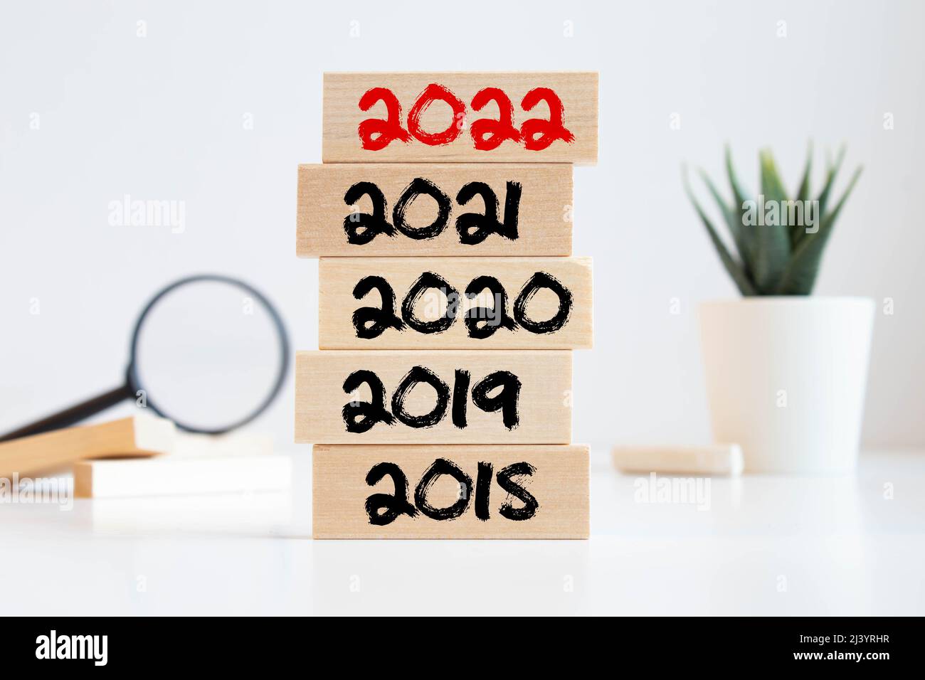 Geschäftsmann baut Holzblöcke 2018, 2019, 2020, 2021. Das Konzept des Beginns des neuen Jahres. Neue Ziele. Nächstes Jahrzehnt. Trends und Veränderungen in t Stockfoto