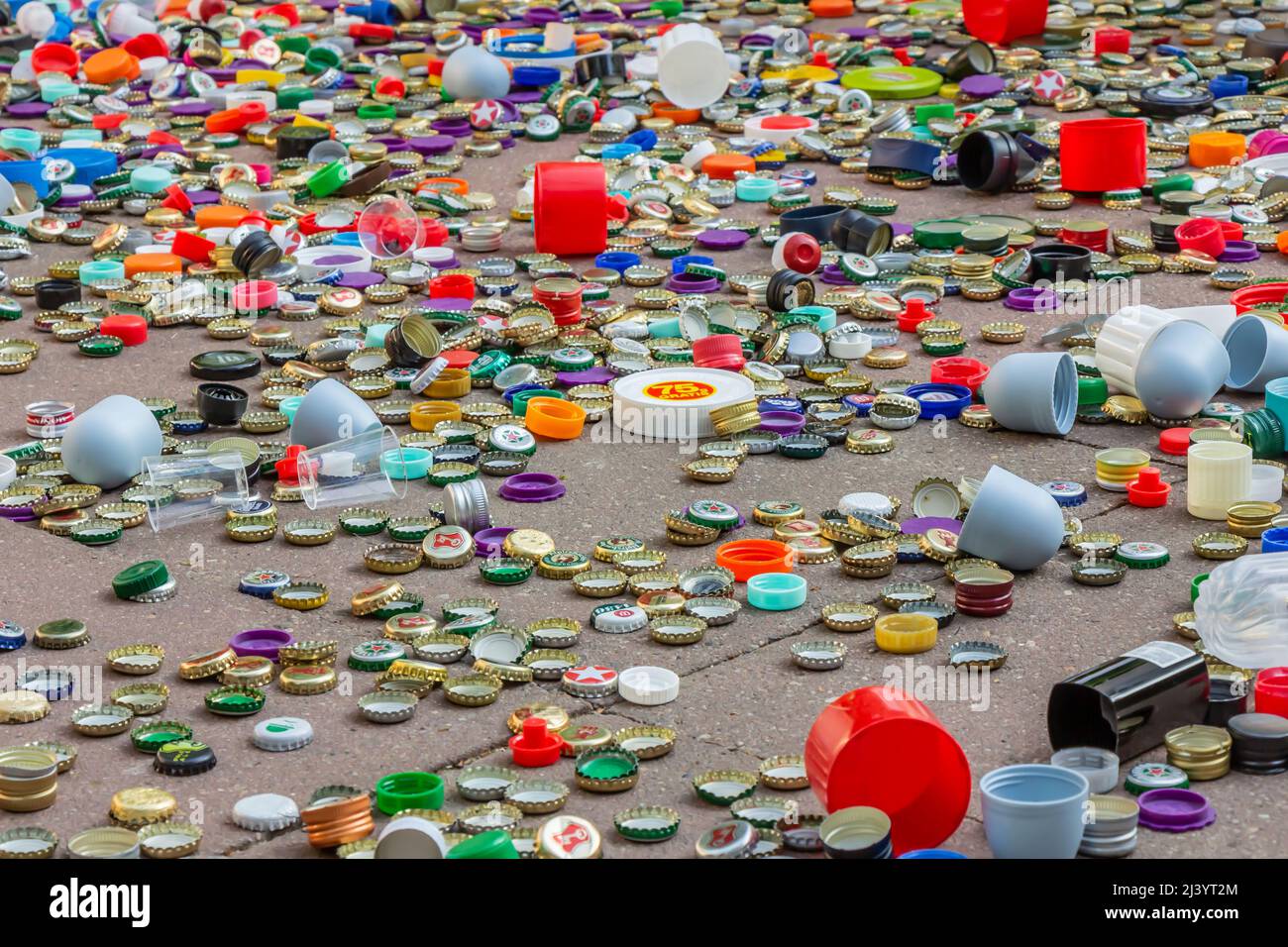 Berlin, Deutschland, 12.05.2018, Tausende Metall- und Kunststoffkappen in Gold, Rot, Grün, Blau, Weiß, Silber usw. auf dem Bürgersteig verstreut. Recycling, e Stockfoto