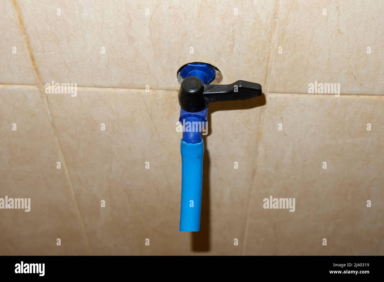 Der blaue Wasserhahn aus Kunststoff befindet sich im Badezimmer Stockfoto
