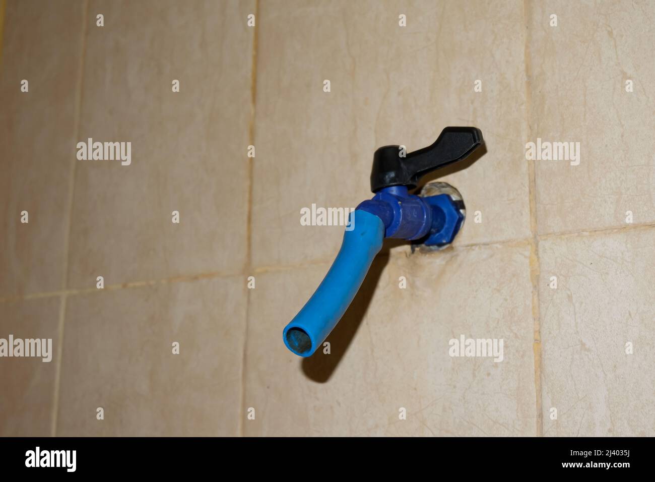 Der blaue Wasserhahn aus Kunststoff befindet sich im Badezimmer Stockfoto