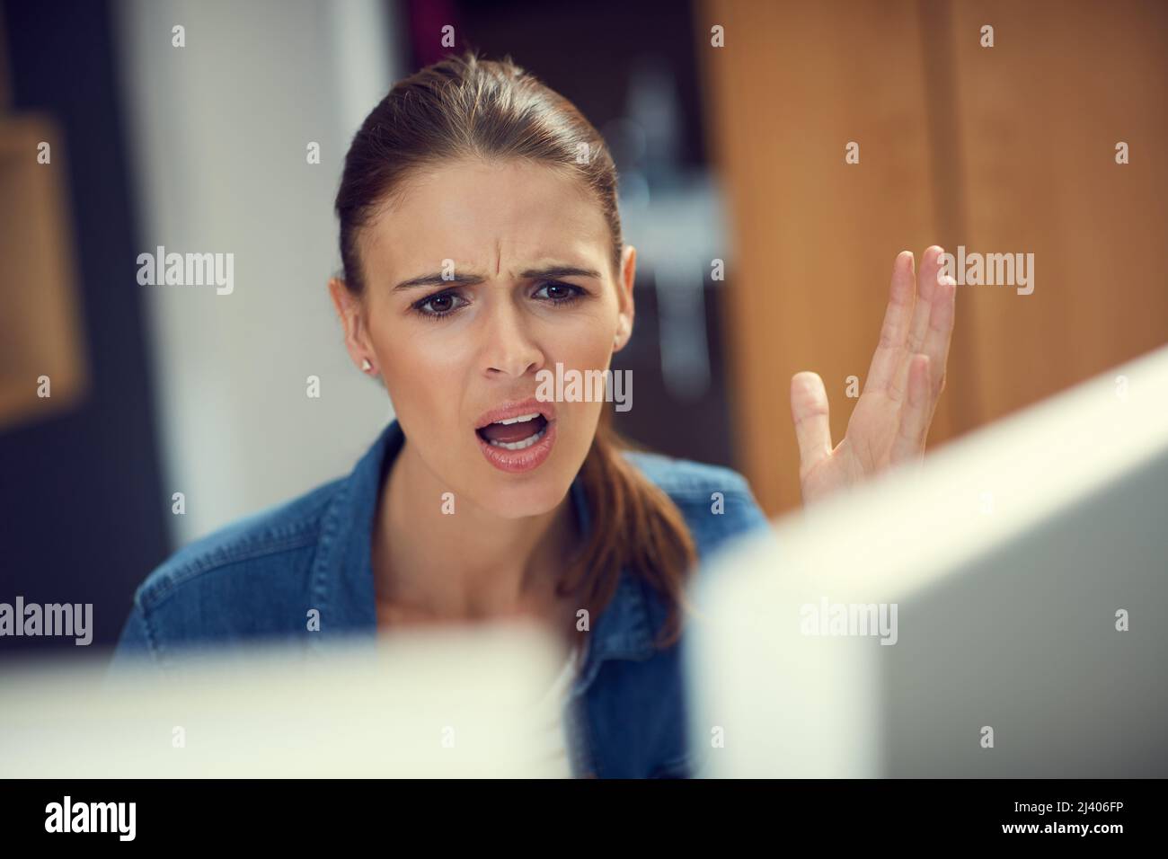 Warum ist das Internet so langsam? Aufnahme einer jungen Geschäftsfrau, die einen Computer benutzt und in einem modernen Büro wütend aussschaut. Stockfoto