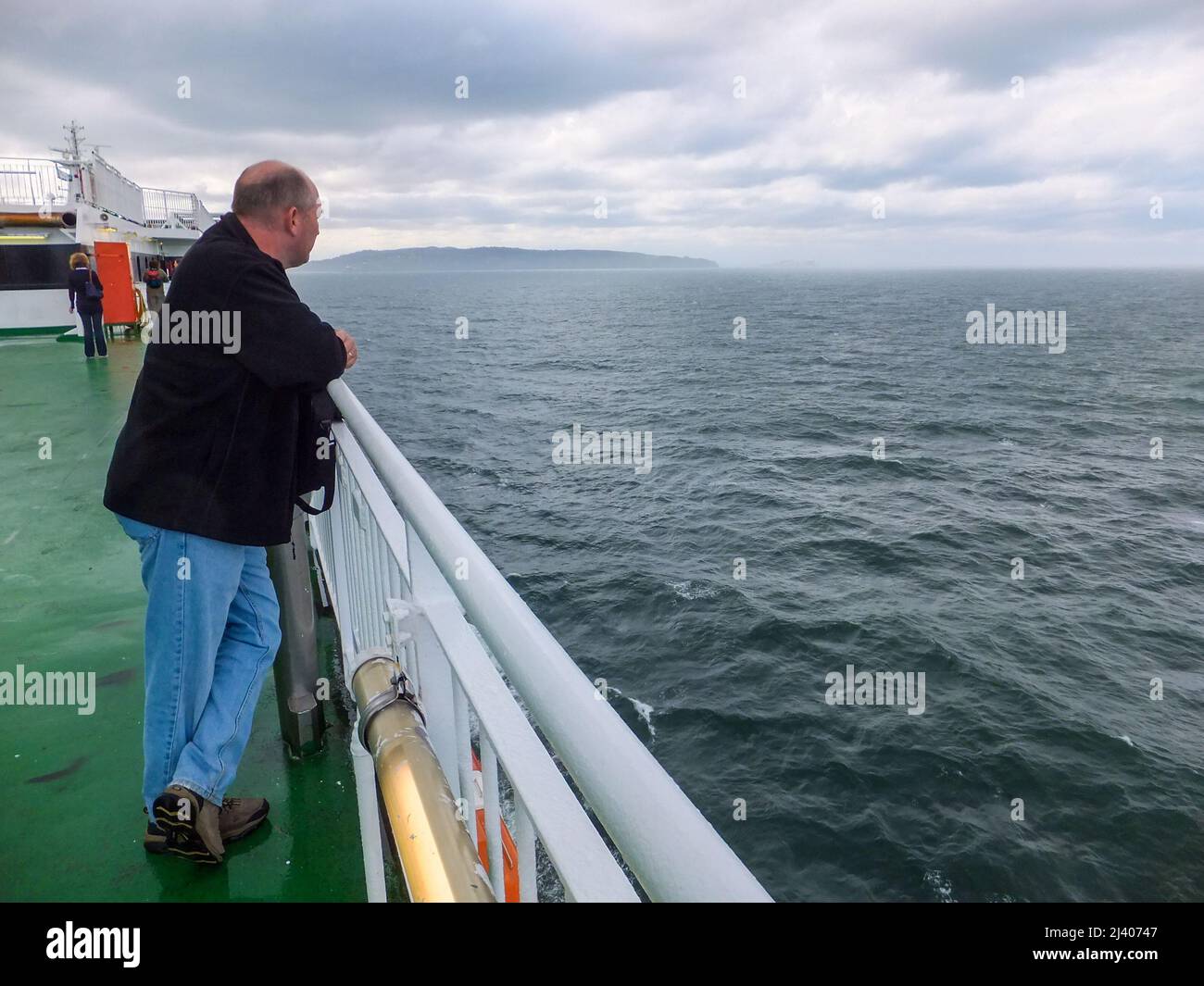 Ein Mann blickt vom Deck der irischen Fähre 'Ulysses' über die Irische See. Stockfoto