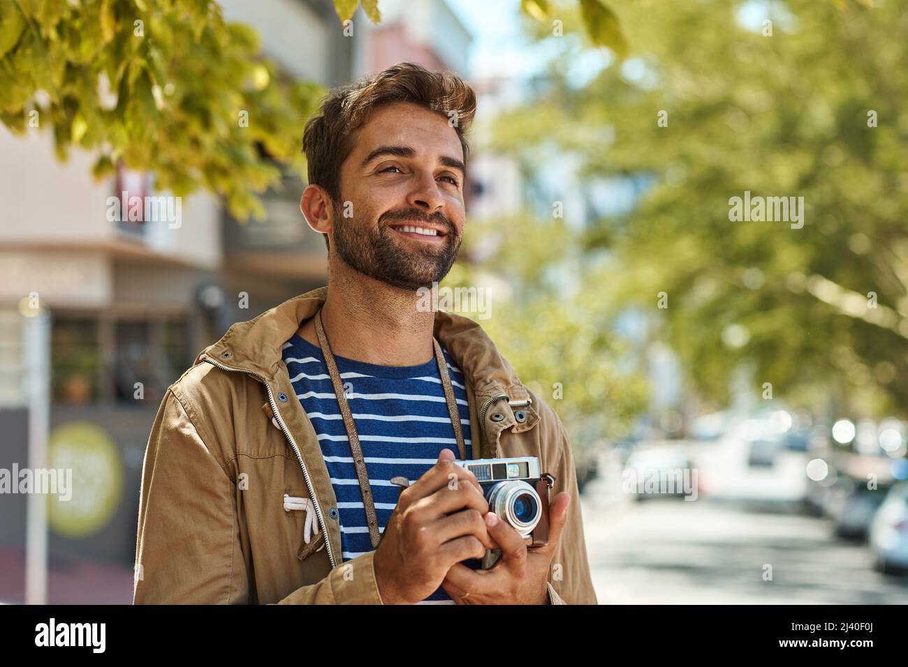 Seine Kamera reist überall hin. Aufnahme eines glücklichen Touristen, der Fotos macht, während er eine fremde Stadt auf eigene Faust erkundet. Stockfoto