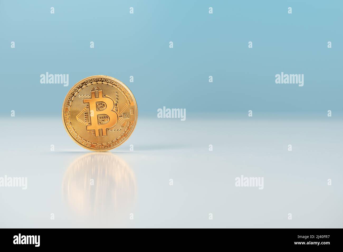 Wachstum oder Anstieg des Preises von Bitcoin. bitcoin steht auf dem Tisch auf hellblauem Hintergrund. Goldenes Bitcoin. Kryptowährung Symbol Bitcoin. Gold Digital Cur Stockfoto