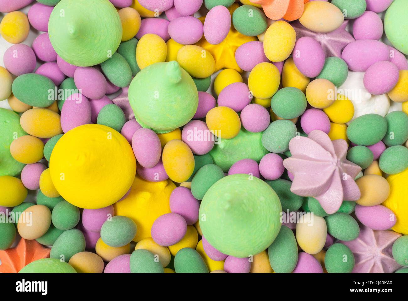 Bunte Baisnüsse und glasierte Erdnüsse isoliert auf weißem Hintergrund. Draufsicht. Stockfoto