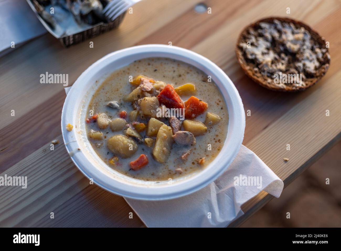 Fischsuppe in einer Pappschüssel mit einem Stück Roggenbrot, serviert auf dem Heringmarkt in Turku, Finnland. Stockfoto