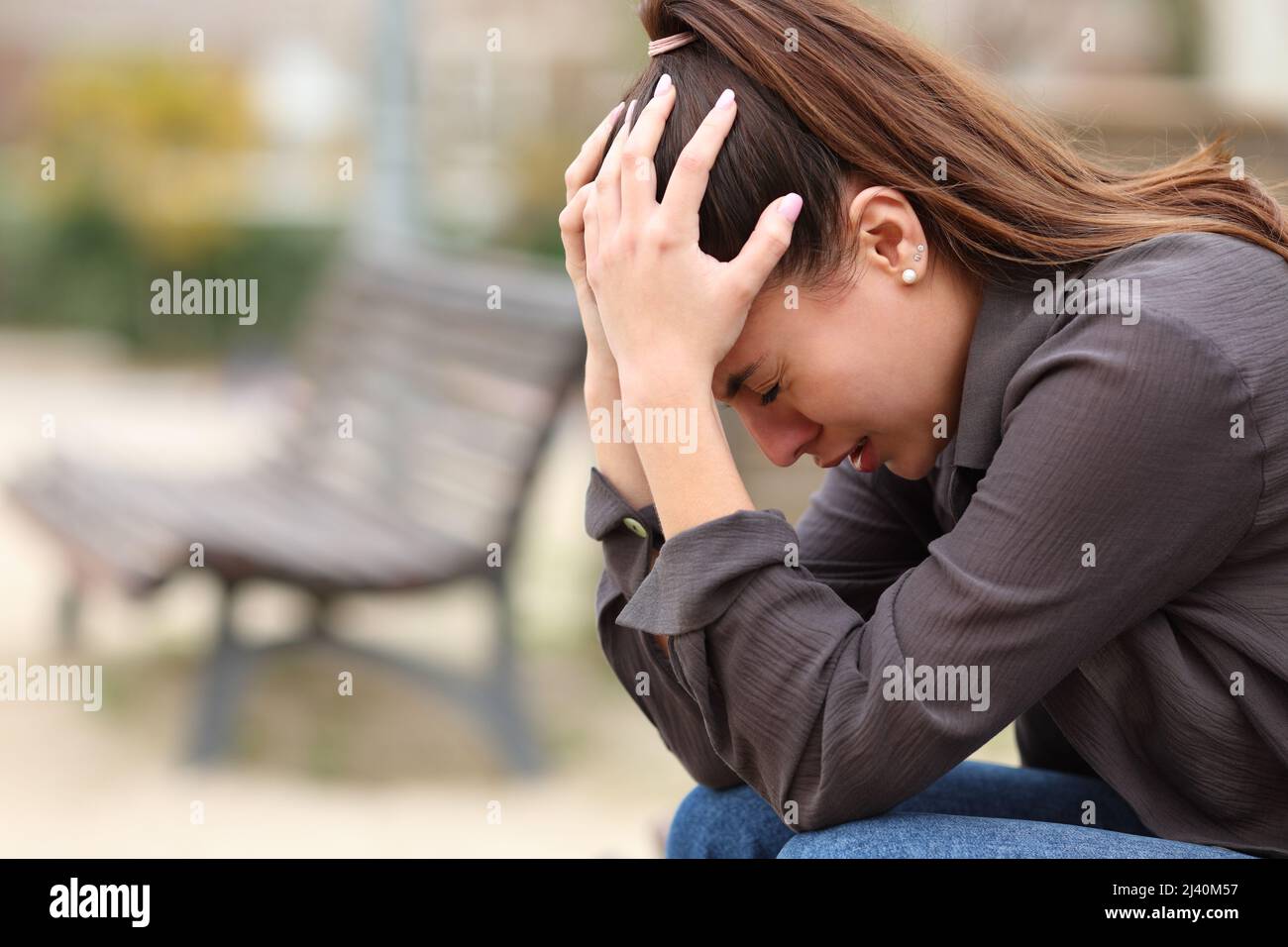 Seitenansicht Porträt einer verzweifelten Frau, die sich allein in einem Park beschwert Stockfoto