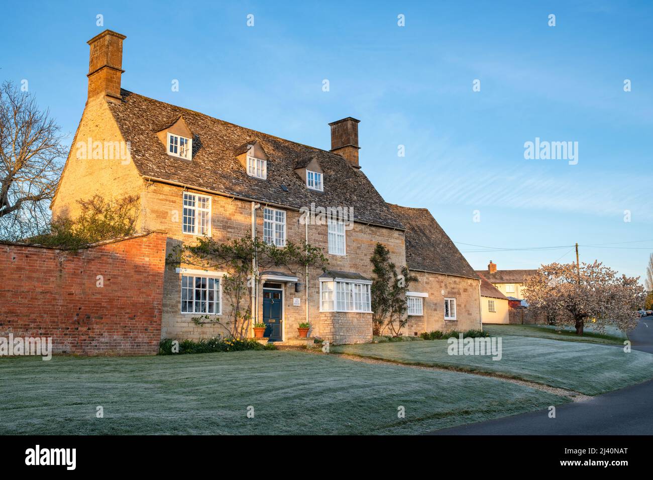 Großes Haus bei Sonnenaufgang an einem frostigen Frühlingsmorgen. Tredington, Warwickshire, England. Stockfoto