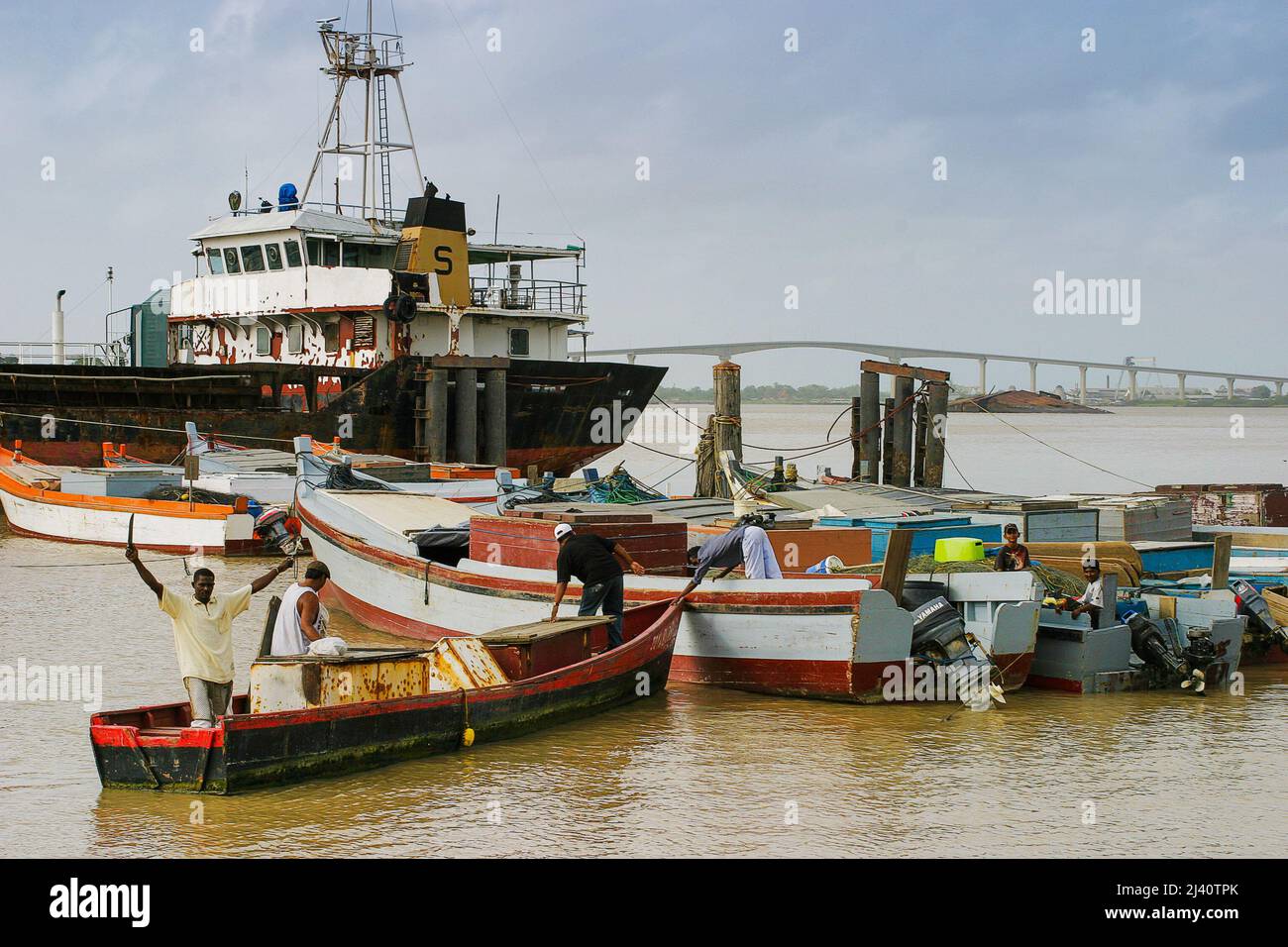 Surinam, kleine Fischer im Hafen von Paramaribo am Fluss Suriname. Die Jules Wijdenbosch Brücke (niederländisch: Jules Wijdenboschbrug), auch genannt Stockfoto